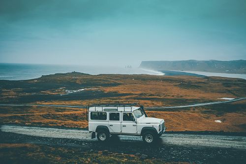 white Jeep SUV on gray rocky road during daytime