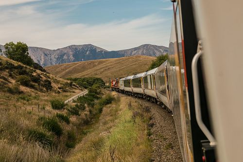 white train with the distance of mountain during daytime