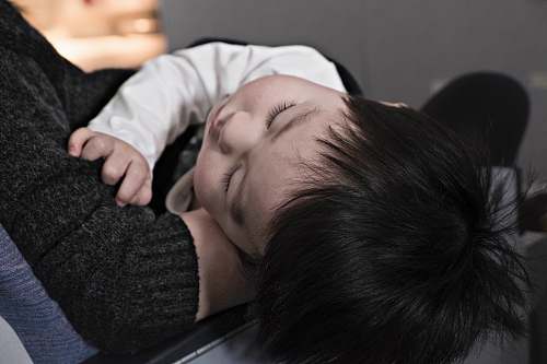 asian toddler sleeping on parent family