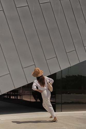 apparel woman standing outside building hat