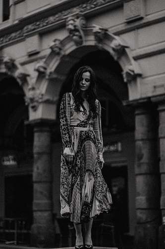 apparel woman wearing black and white maxi dress near white building black-and-white