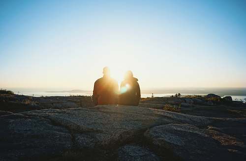 sunset silhouette of two person during sunrise sunlight