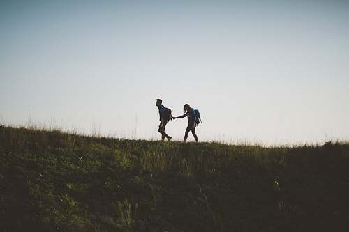 walking couple walking on hill while holding during daytime lantau island
