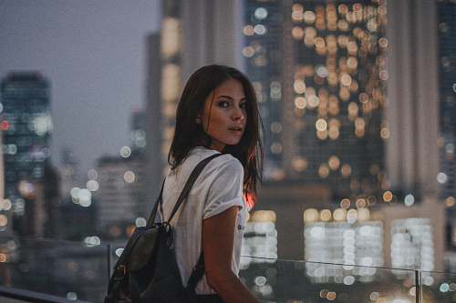 person woman in white t-shirt carrying black leather backpack people