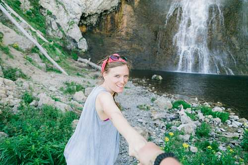 people woman standing far away from waterfall person