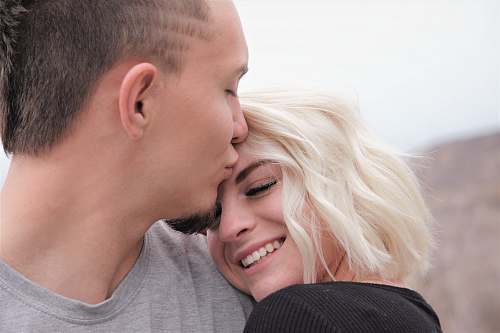 person man kissing woman's forehead kissing