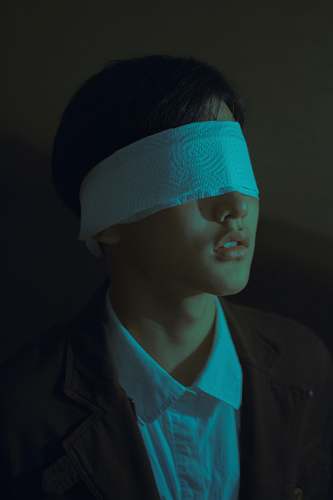 people covered eyes of man wearing white and brown suit human