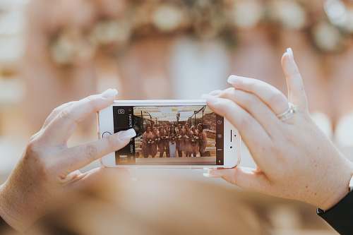 iphone person holding iPhone capturing group of women bridal party