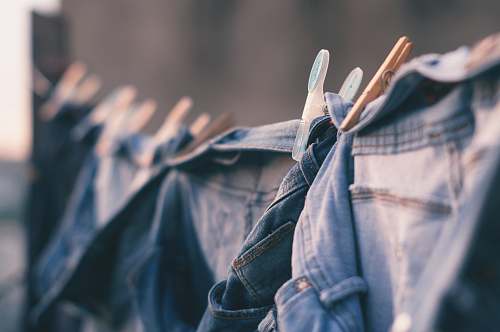 person selective focus photo of blue denim jeans hanged people