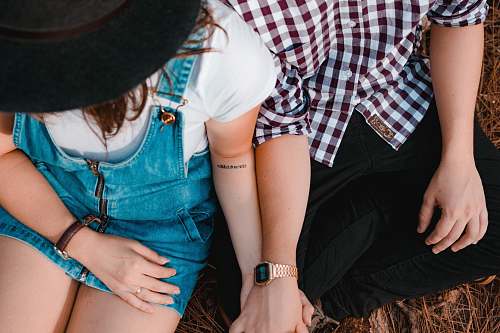 couple couple holding hands while sitting hat