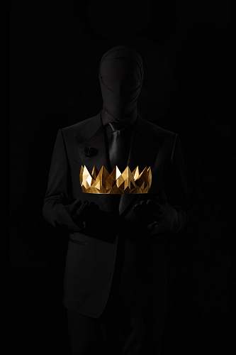 clothing person in black suit jacket holding gold crown human