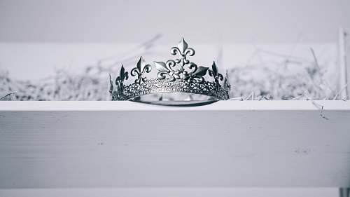 tiara silver-colored crown on top of white wood ornament