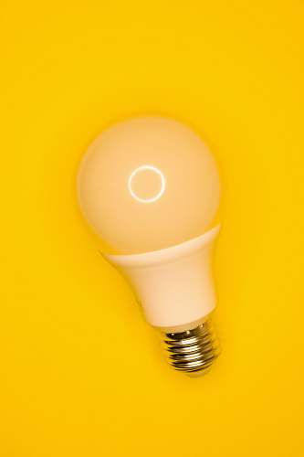 lightbulb white light bulb on yellow surface ascoli piceno