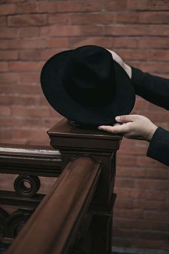 clothing person holding black hat hat