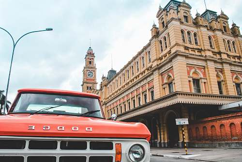 car red Dodge pickup truck near building luz station