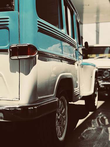 transportation white and teal vehicle parked front of white vehicle car