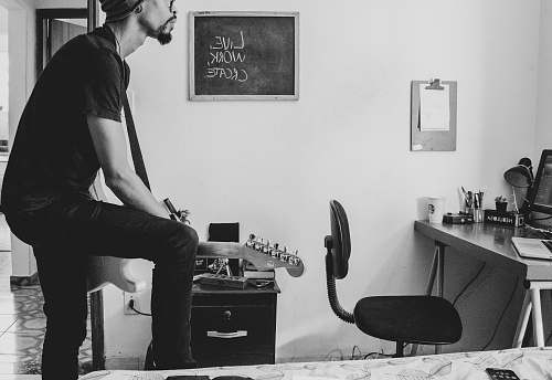 black-and-white grayscale photo of man playing guitar people