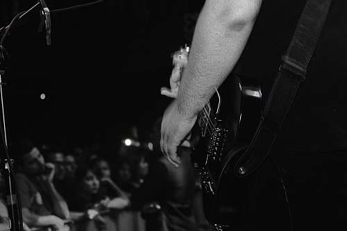 people grayscale photo of person playing guitar black-and-white
