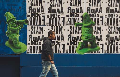 person man waling beside a multicolored wall people