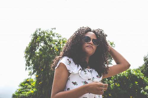 person woman with sunglasses standing near green leafed tree outdoor during daytime people