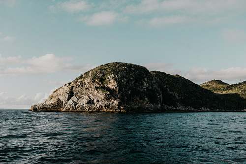 land mountain surrounded by body of water outdoors