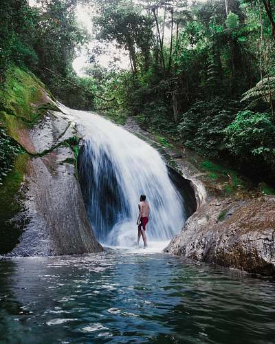 water man standing in front of waterfall waterfall