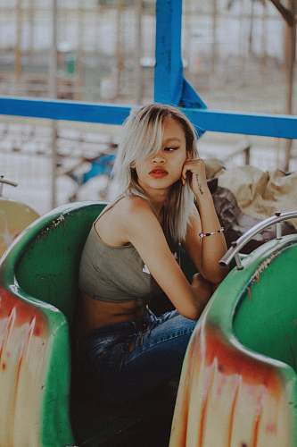 human woman in gray crop top sitting on green chair people