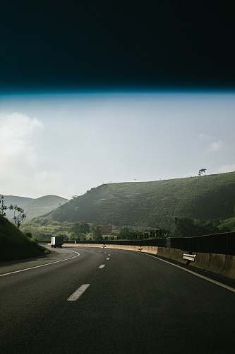 asphalt black asphalt road between green mountains tarmac