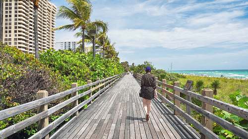 person woman walking on brown dock apparel