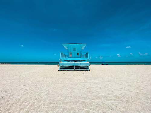 water blue and white lifeguard house on beach during daytime sea