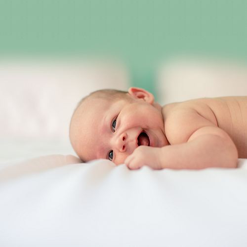 baby lying on fabric cloth