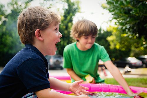 boy in blue shirt screaming near boy in green crew-neck shirt