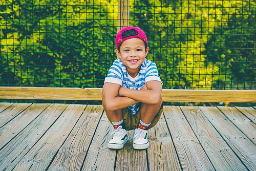 boy on wooden porch near railing