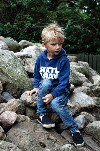 boy seating on rock fragments