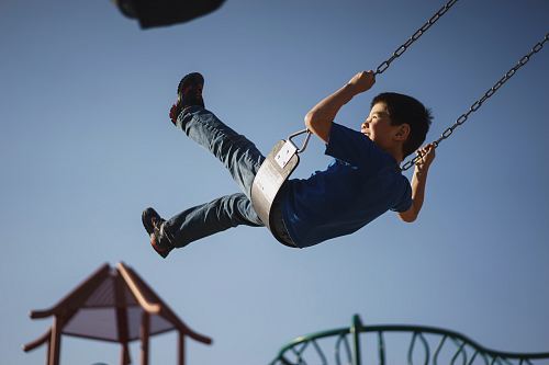 boy sitting on swing chair