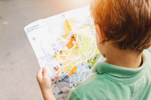 boy standing while reading map
