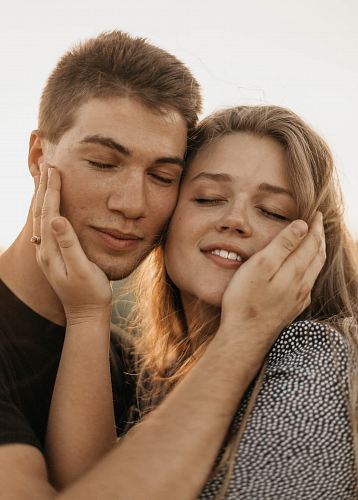 close-up photography of man and woman hugging on face each other during daytime