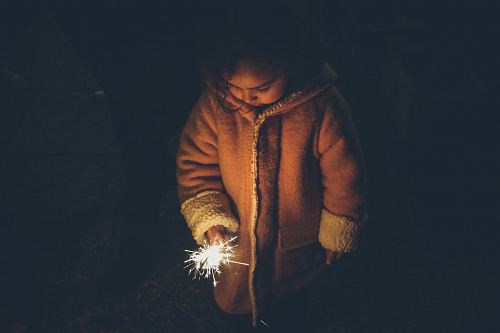 girl holding sparkler at nighttime