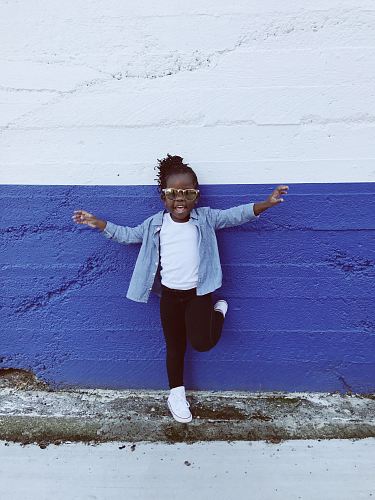 girl leaning on wall during daytime