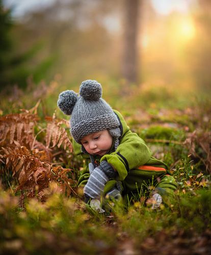 selective focus photo of baby on green grass field