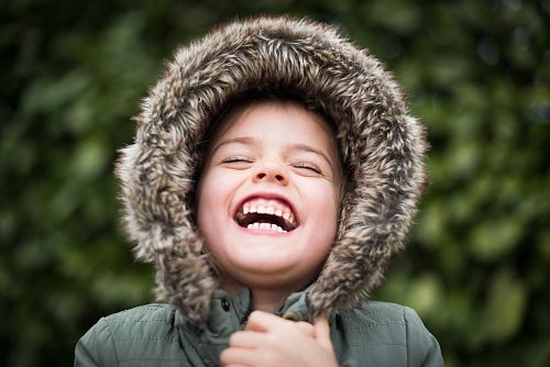 selective focus photography of child laughing