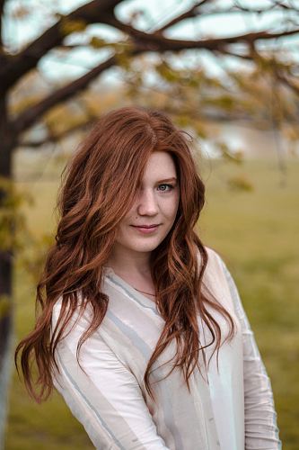 smiling woman in white and gray long-sleeved shirt