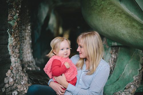woman holding child while sitting down