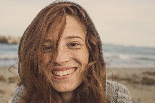 woman smiling wearing grey knit top