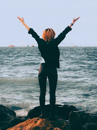 woman standing on shore near sea