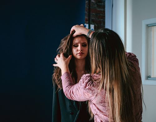 woman touching the hair of other woman