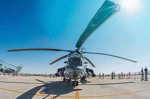 blue people walking and standing near gray helicopter aircraft