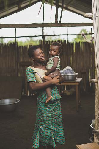 person smiling woman standing while holding baby togo