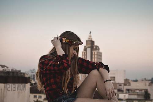 person woman in red and black checked sport shirt with white high rise building backgorund people