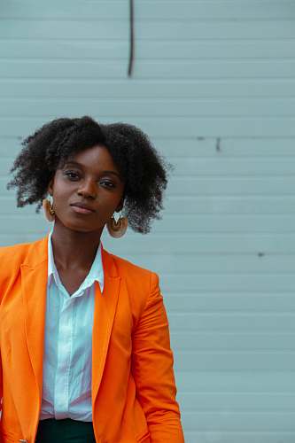 person woman standing near white wall hair